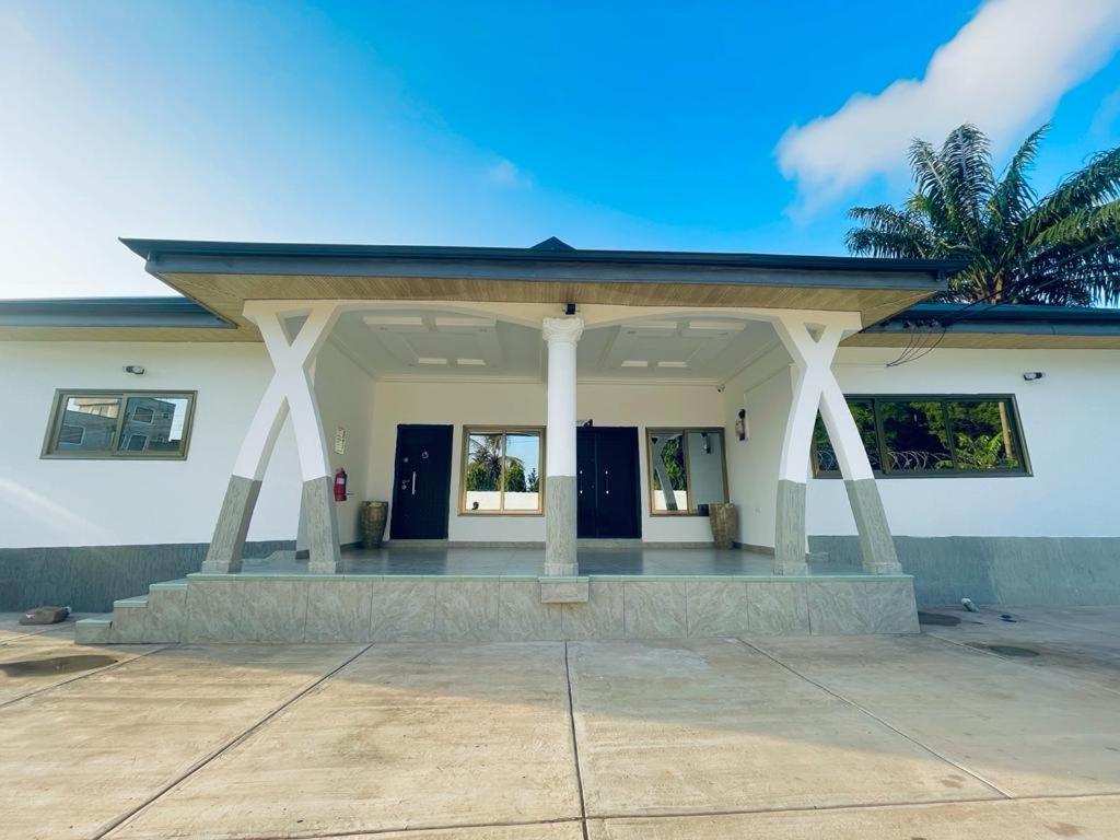 a building with a porch with a roof at Rakka Guest House in Adentan