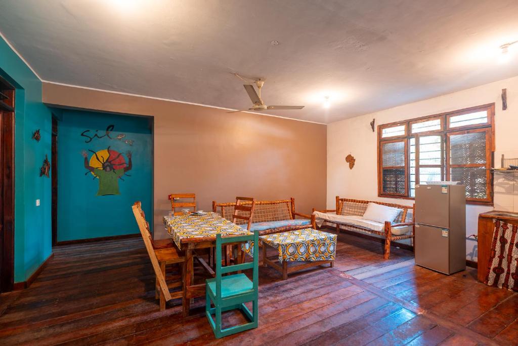 uma sala de estar com uma mesa e um sofá em Kiungani Lodge em Jambiani