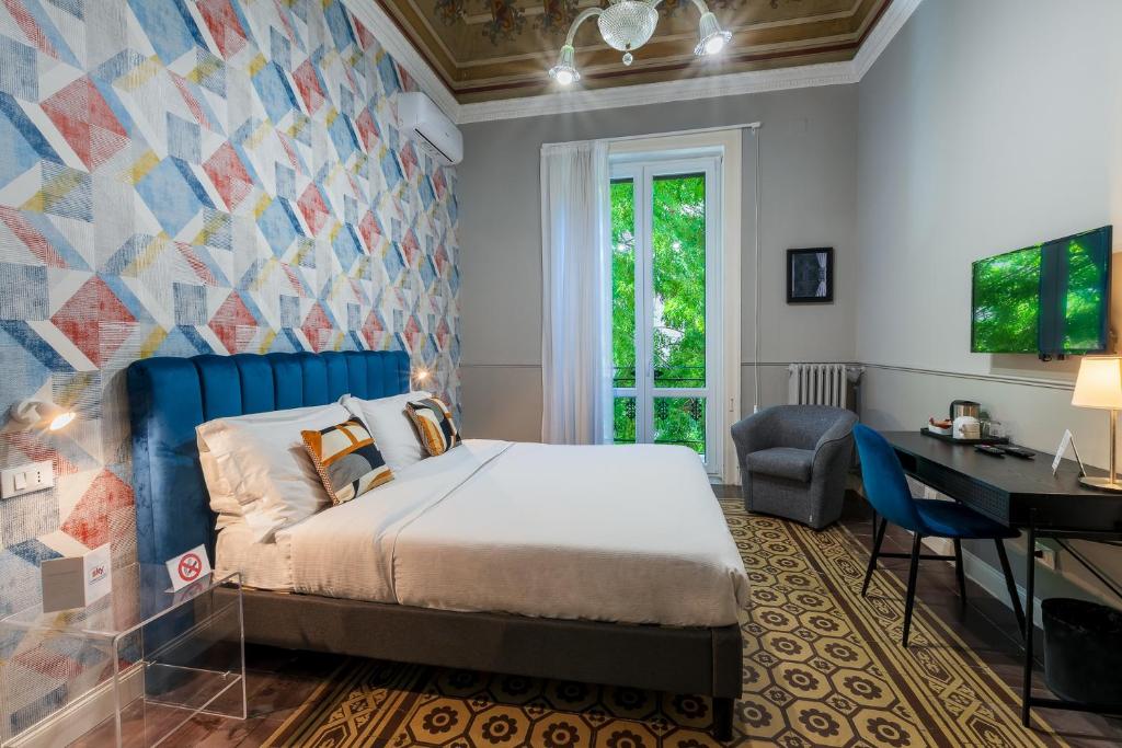 a bedroom with a bed and a desk at casa mo room and suite in Palermo