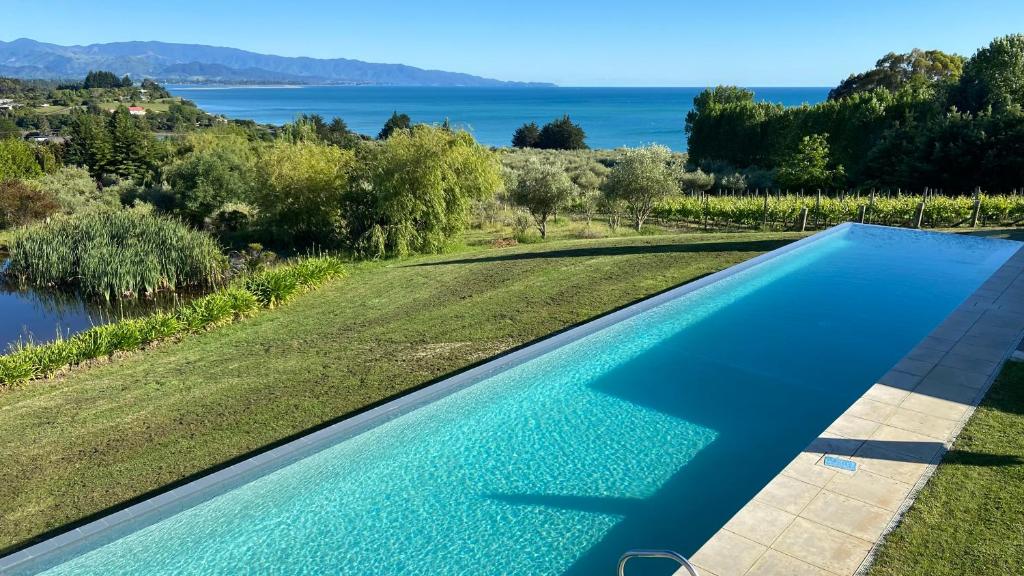 een infinity pool met uitzicht op het water bij Windhover Estate in Tasman