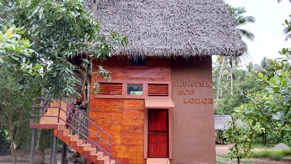 mały dom z dachem krytym strzechą i schodami w obiekcie ULPATHA ECO LODGE w mieście Kurunegala