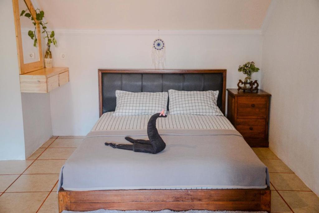 a bedroom with a bed with a black snake on it at Pigeon Mandala Apartments & Resto in Nusa Dua