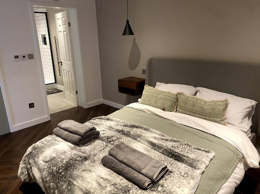 a bedroom with a bed with towels on it at The Retreat, luxury apartment in Bath with parking in Bath