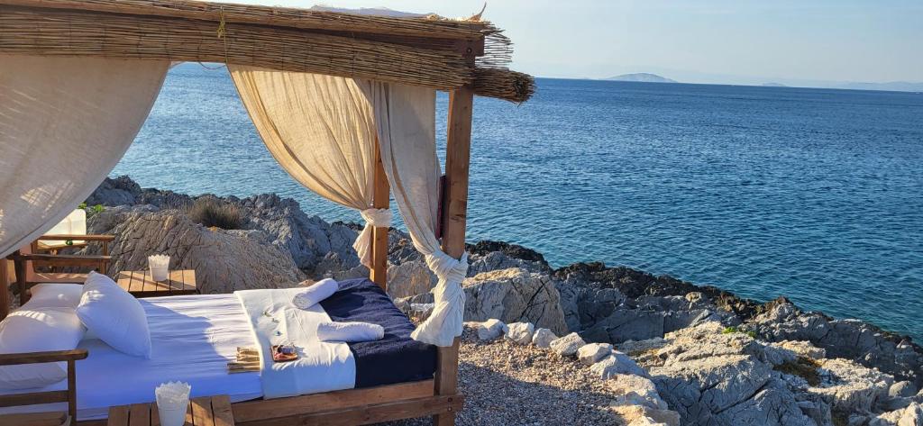 a bedroom with a bed on the rocks by the water at Aponisos island in Megalochori