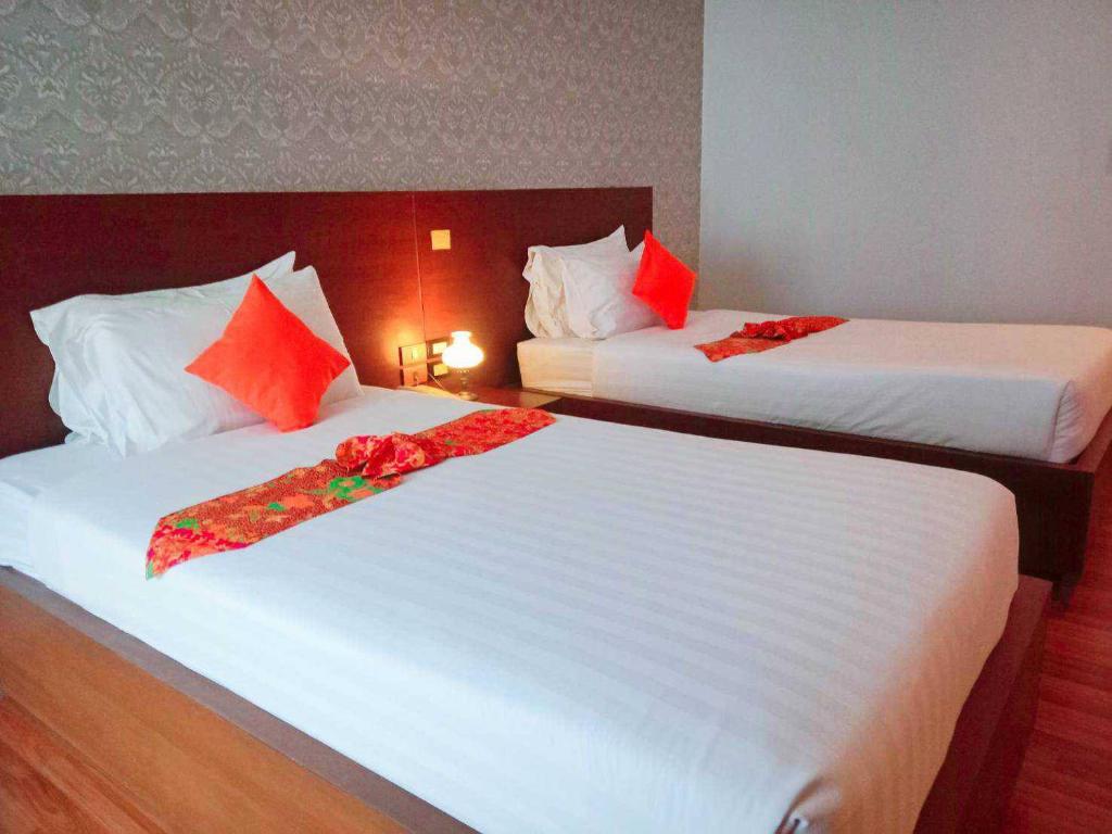 Postel nebo postele na pokoji v ubytování Jingjit Hotel