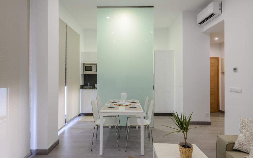 a dining room with a white table and chairs at Apartamentos Lanceata in Revolta