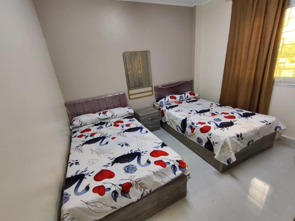 ein Schlafzimmer mit zwei Betten und einem Fenster in der Unterkunft compound gardenia city in Kairo