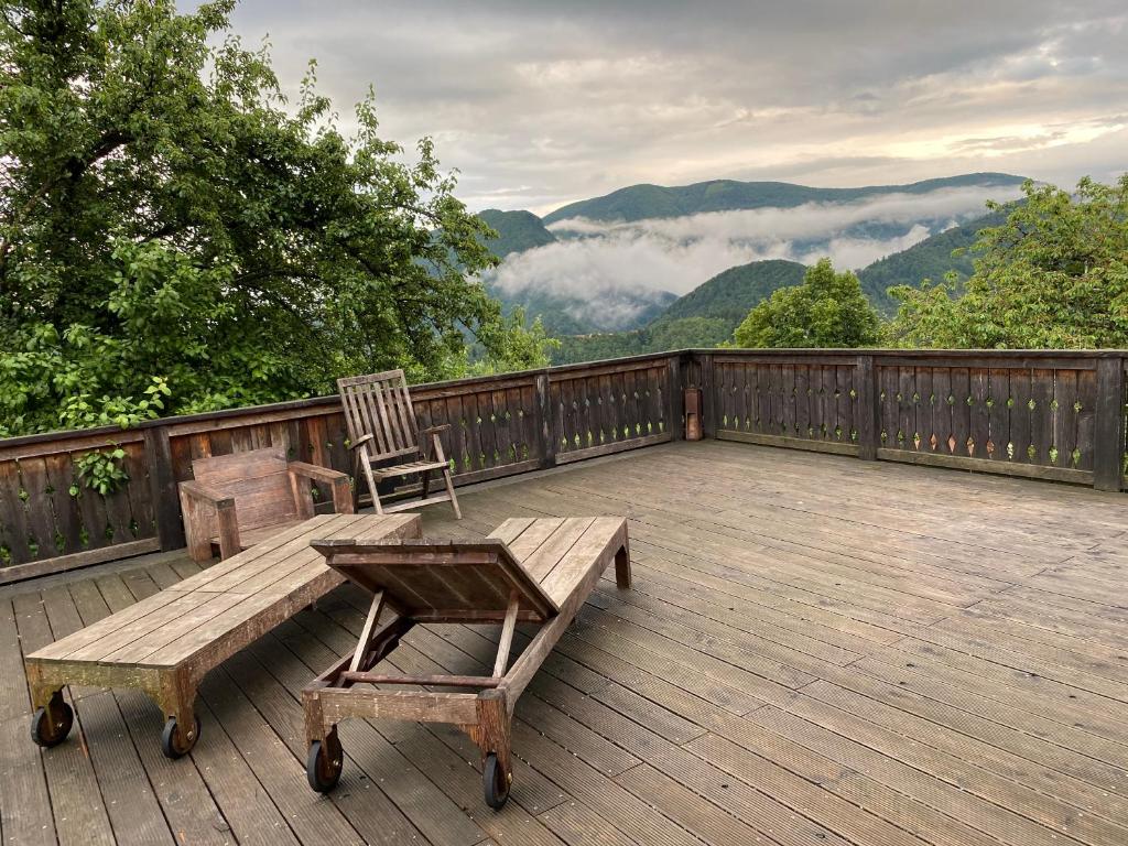 una terraza de madera con un banco y una silla. en Stunning Hills View Apartment Vransko, en Vransko