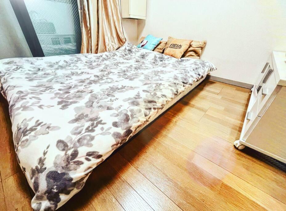 Ce lit se trouve dans une petite chambre dotée de parquet. dans l'établissement 駅から徒歩5分！便利リーズナブル, à Tokyo