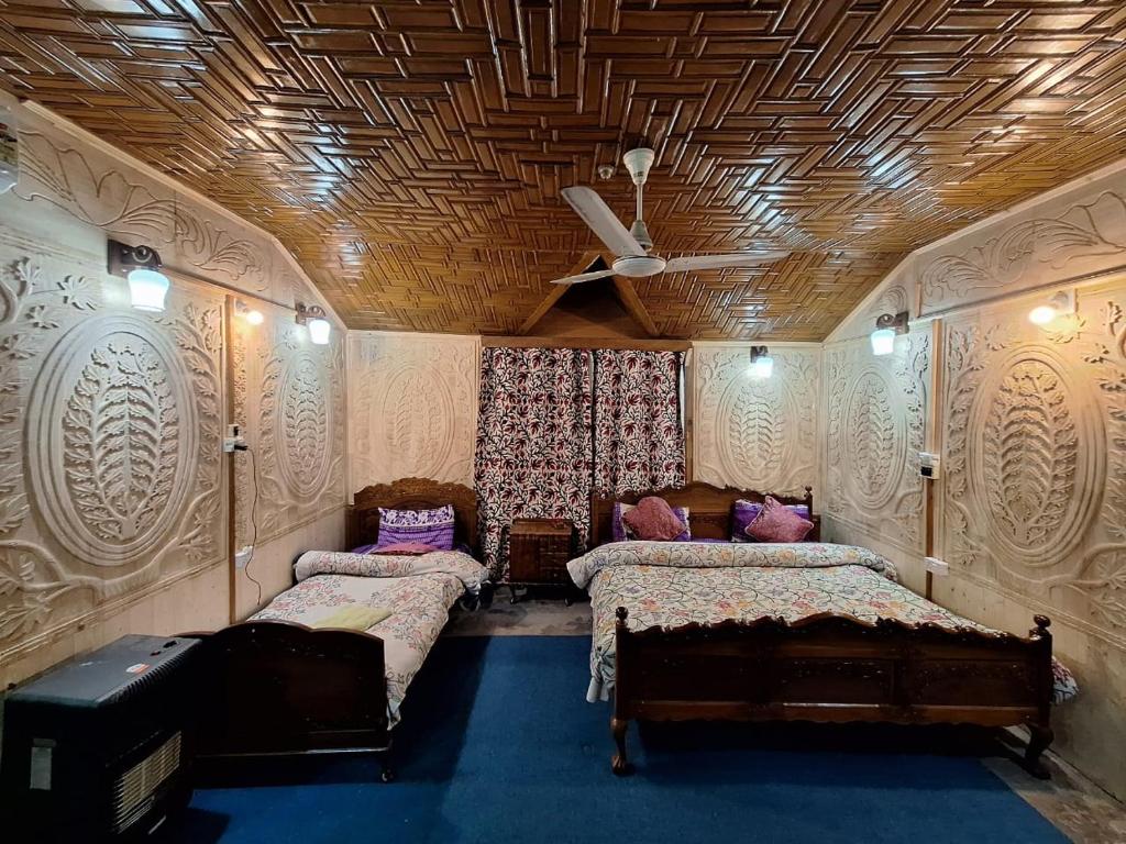 a bedroom with two beds in a room with a ceiling at Houseboat Young Snow View Front Line Dal Lake in Srinagar