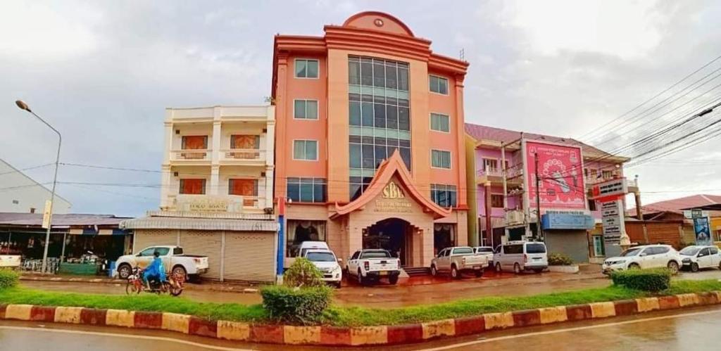 a large building with cars parked in front of it at Soubundith Hotel in Pakse