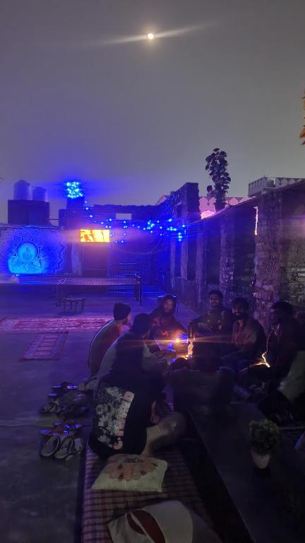 a group of people sitting around a fire at night at ANAND HOSTEL in Pushkar