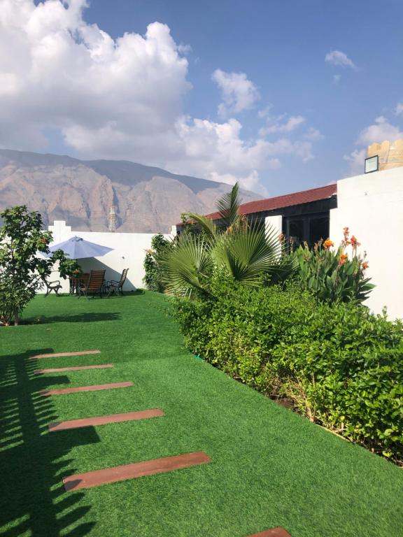 a garden with green grass and mountains in the background at استراحة الدرر خاصه لنساء ولازواج 