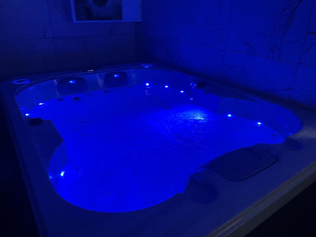 a blue tub in a dark room with lights in it at Main de Bouddha et nonchalance in Arras