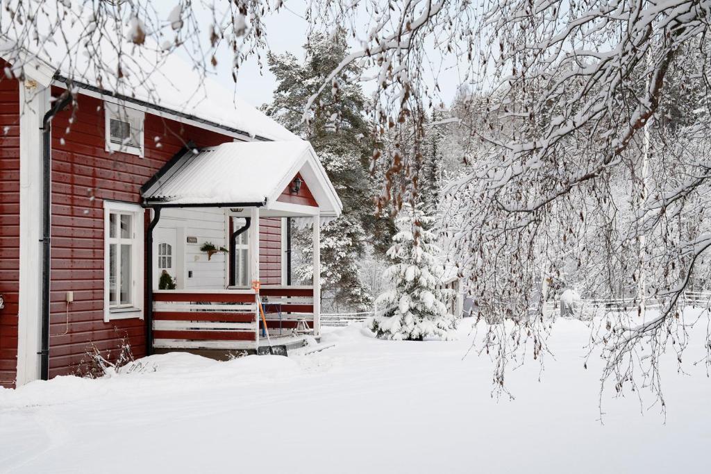 a small red house with snow on it at Torpet i Sjö in Nyland