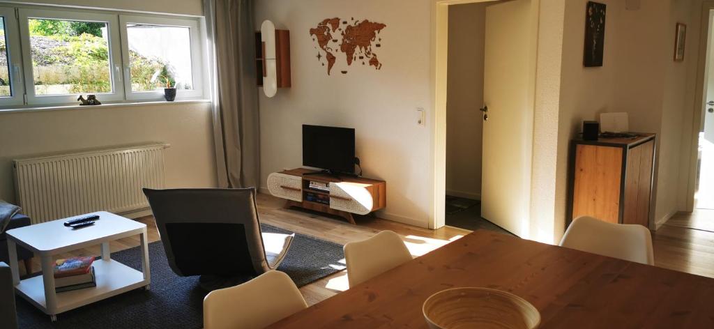 sala de estar con mesa, sillas y TV en Ferienwohnung Albbruck/Albert en Albbruck