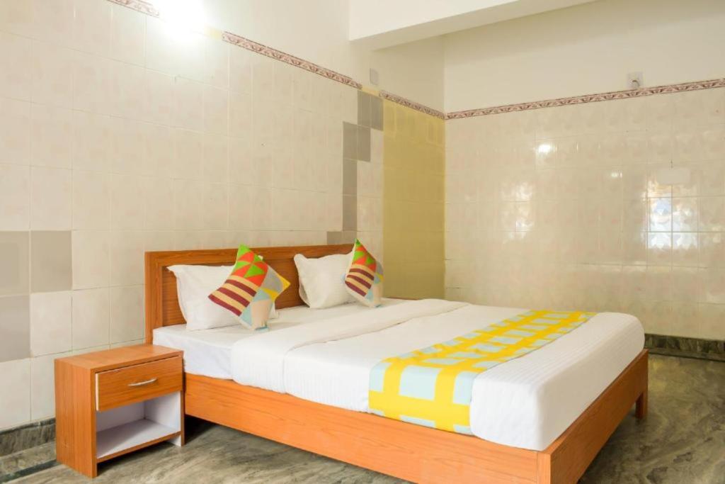 a bedroom with a large bed and a night stand at Goroomgo Elite Stay Bhubaneswar in Bhubaneshwar