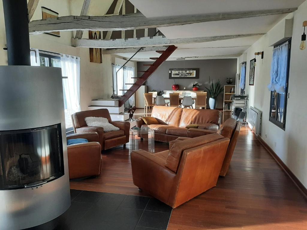 - un salon avec des meubles en cuir et une télévision dans l'établissement CLOS BIOLETTE, à Vismes