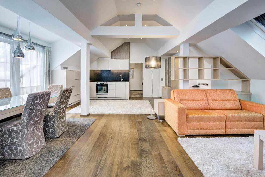 an open kitchen and living room with an orange couch at Hotel Brigitte in Ischgl