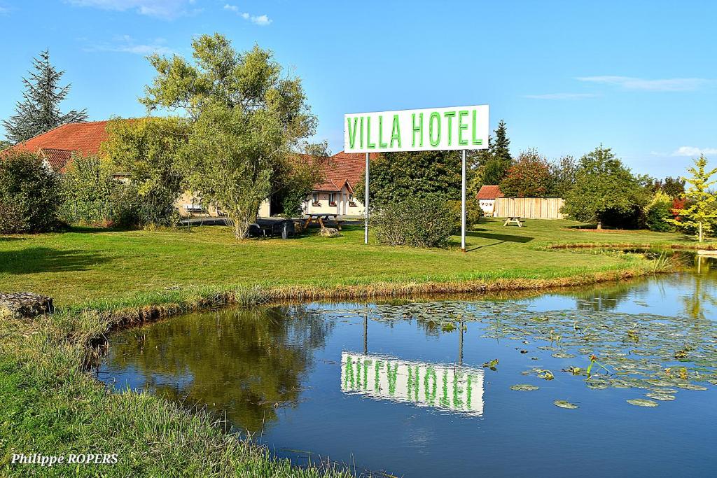 un panneau indiquant un hôtel de villa à côté d'un étang dans l'établissement Villa Hotel, à Poilly-lez-Gien