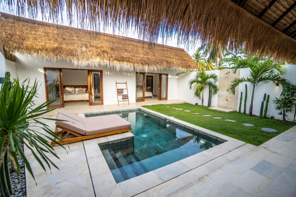 einen Hinterhof mit einem Pool und einer Villa in der Unterkunft Palm Merah Villas - Private pool in Selong Belanak
