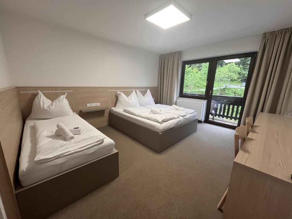 een hotelkamer met 2 bedden en een raam bij Stubnerhof in Bad Gastein