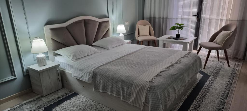 um quarto com uma cama grande e 2 cadeiras em Квартира в новом жилом комплексе Mega Tower em Tashkent