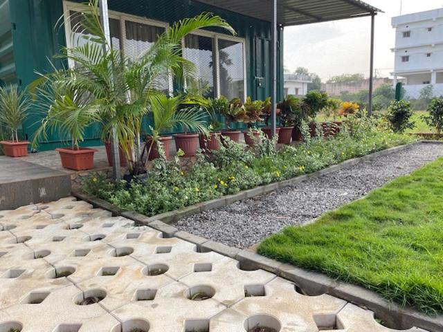 um jardim com vasos de plantas e um edifício em Cozy Cabin very close to Beach em Visakhapatnam