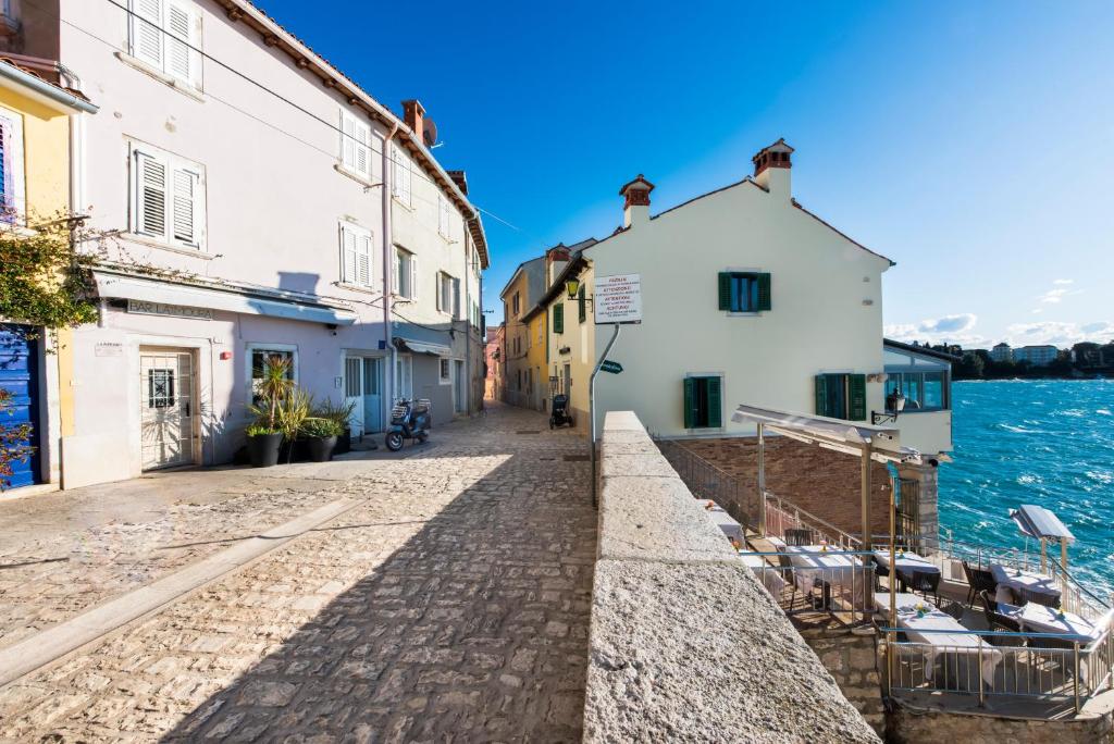 a street in a town next to the water at Apartman Beppo in Rovinj