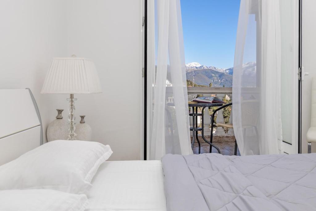 Schlafzimmer mit einem Bett und Blick auf einen Balkon in der Unterkunft Elegance Duplexes by Monte Aria in Herceg-Novi