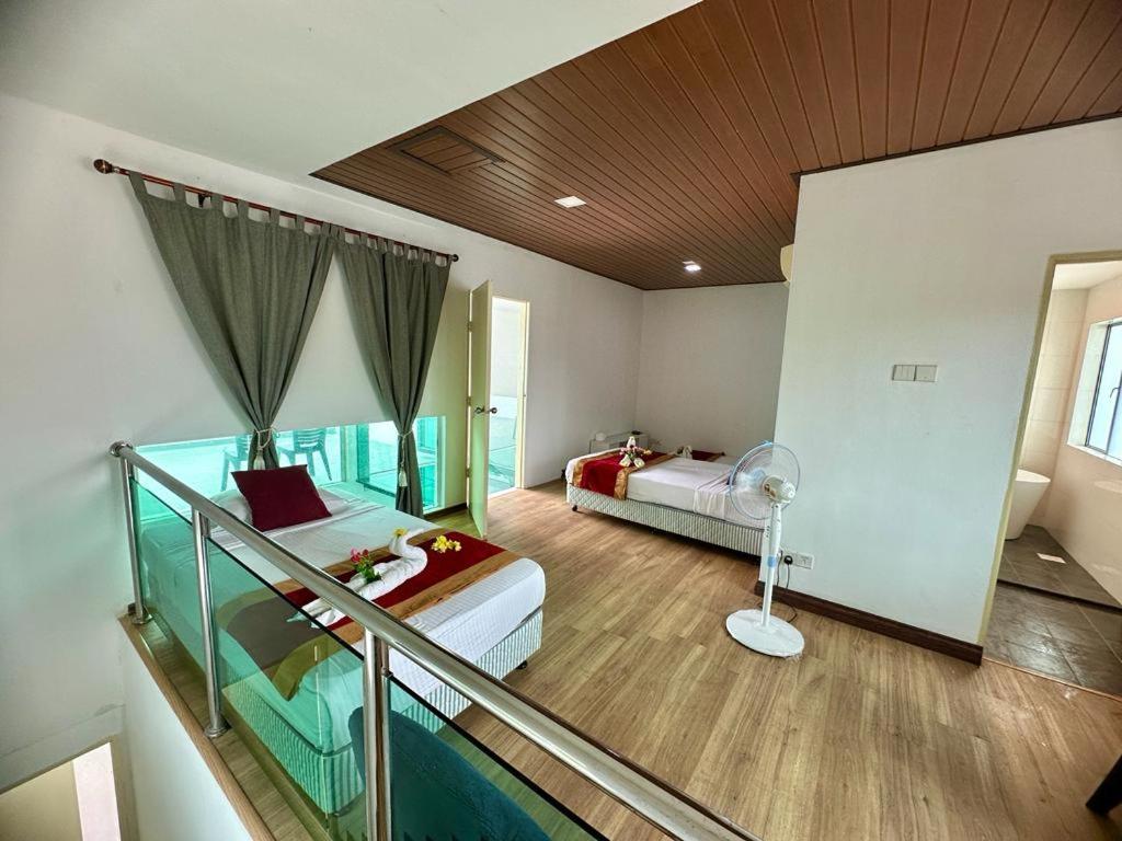 1 dormitorio con 2 camas y balcón en Bahagia Makmur Homestay, en Temerloh