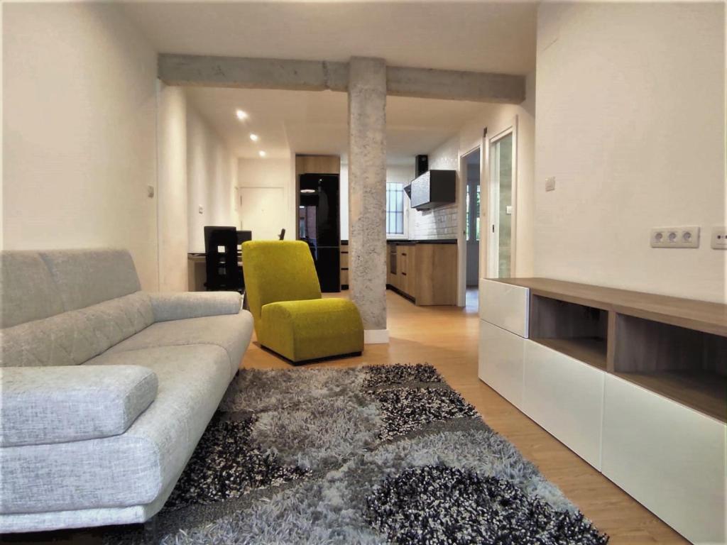 a living room with a couch and a yellow chair at Bonito Apartamento en Zamakola in Bilbao