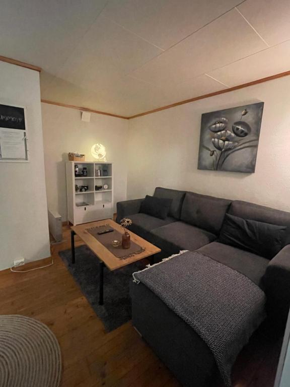 un soggiorno con divano e tavolo di Liten eldre og koselig studiohybel a Svolvær