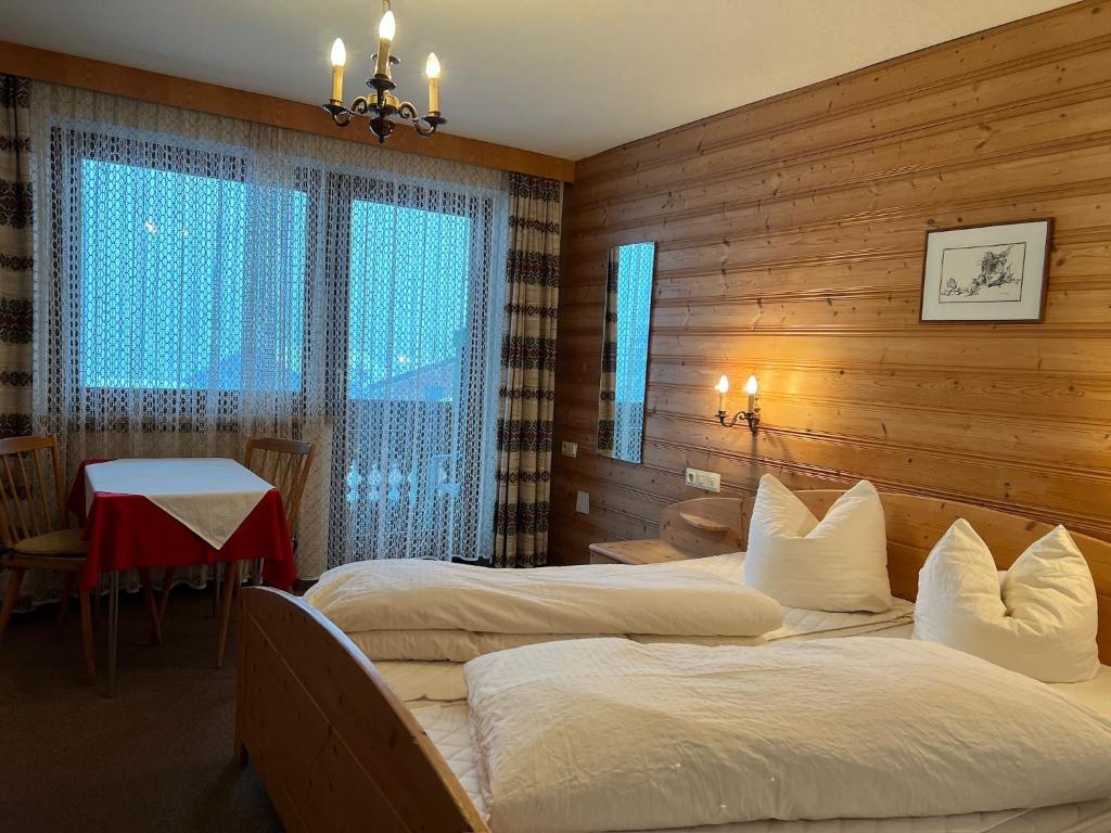 um quarto de hotel com duas camas e uma mesa com uma mesa em Gästehaus Tauscher am Haldensee em Haldensee
