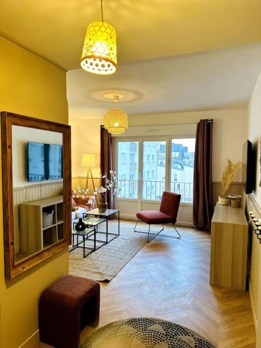 un salon avec un canapé et une chaise dans l'établissement Le Haut Mabilais - Centre Rennes, à Rennes