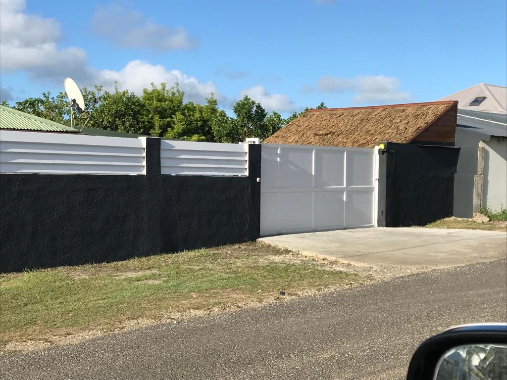 a white fence in front of a house at LA PAILLOTE D OR in Sainte-Anne