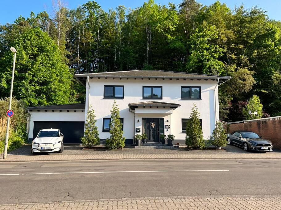 una casa blanca con dos coches aparcados delante de ella en Amazing House in Kaiserslautern, en Kaiserslautern