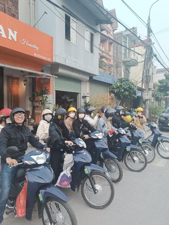 a group of people riding motorcycles down a street at An Homestay & Hostel Motorbikes & Tours in Cao Bằng