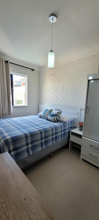 1 dormitorio con cama, ventana y TV en Recanto da Gabriela - Apartamento para temporada na zona sul de ilhéus en Ilhéus