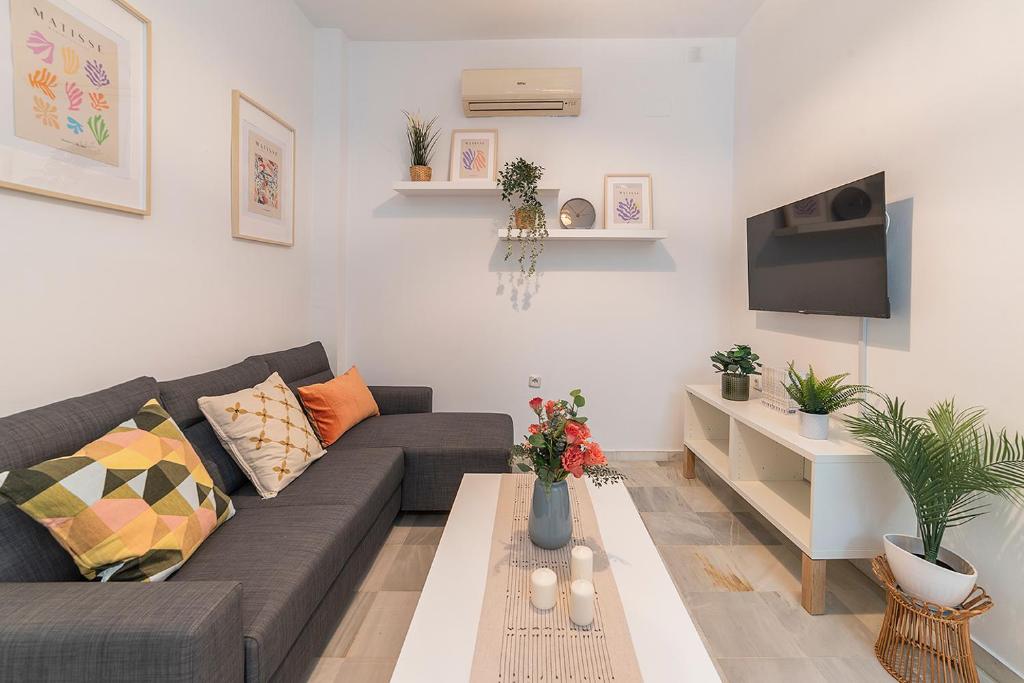 ein Wohnzimmer mit einem Sofa und einem Couchtisch in der Unterkunft AlohaMundi Torres in Sevilla