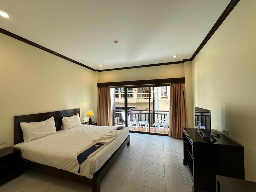 um quarto com uma cama, uma secretária e uma janela em Baan Kingkeaw Thamdee Patong em Patong Beach