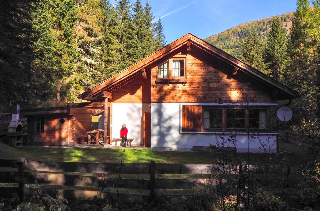 une personne debout devant une maison dans l'établissement Fleissner Hütte, à Innerkrems