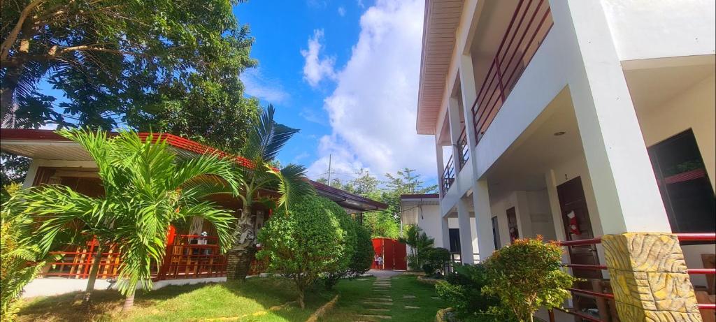 un cortile di una casa con alberi e piante di Roos Guesthouse a Moalboal