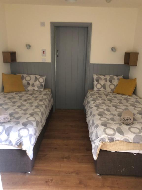 two beds sitting next to each other in a room at The Snug, Ardfert Village in Ard Fhearta