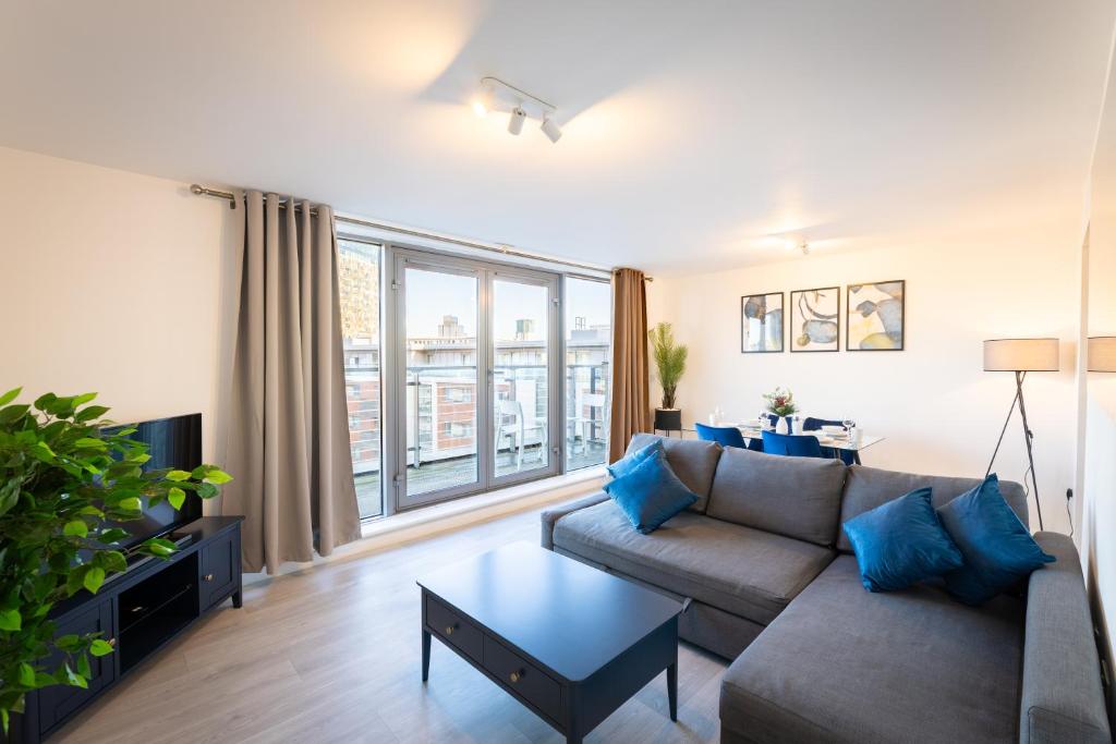 a living room with a couch and a large window at Penthouse City Centre - Luxury Apartment in Birmingham