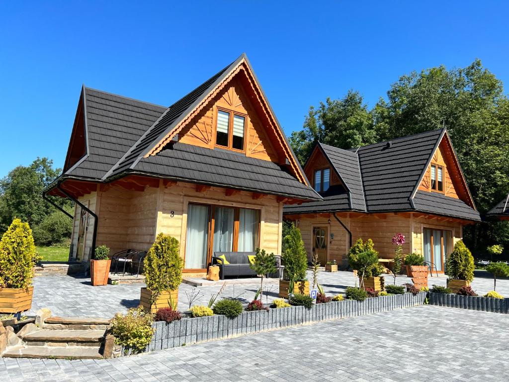a house with a black roof at Żabie Dworki Witów Luxury Chalets & SPA in Witów