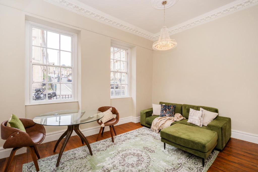 a living room with a green couch and a glass table at Alfred Apartment - Beautiful Central Bath Location in Bath