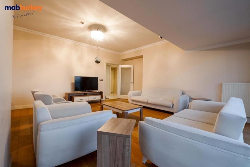 a living room with white furniture and a flat screen tv at القدس شعفاط in Bet Zayit