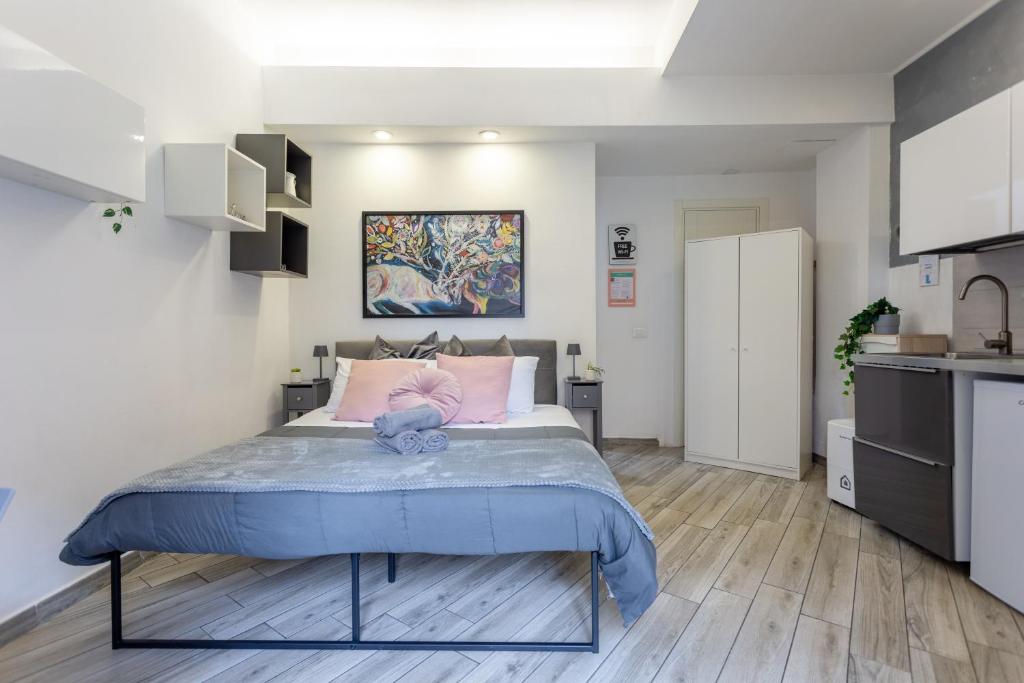 1 dormitorio con 1 cama grande con almohadas rosas en Holiday Homes Rome - Portuense 21 - Studio with little private Garden, en Roma