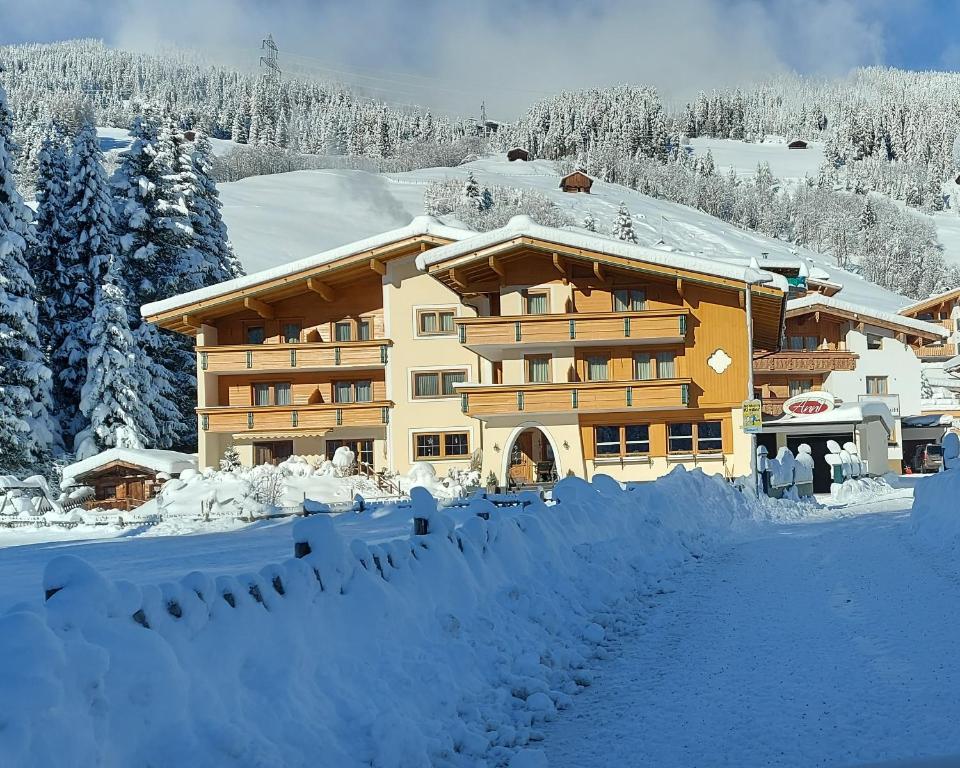 a large building covered in snow with trees in the background at Garni Anni in Gerlos